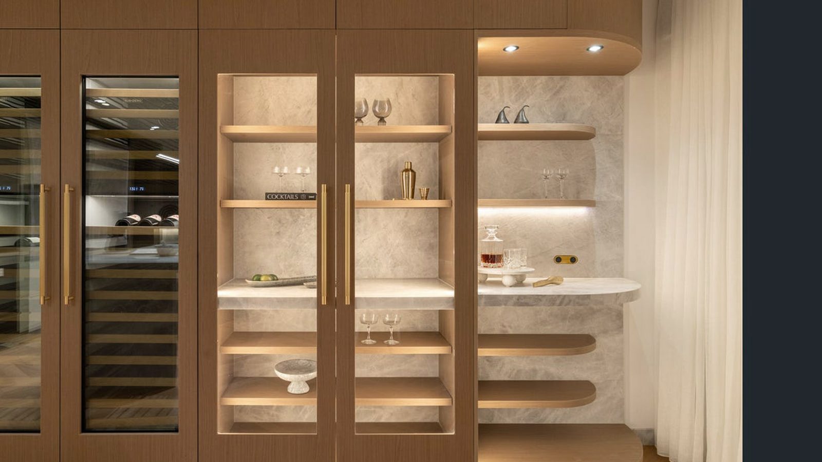 Custom bar display cabinetry with glass doors and brass hardware